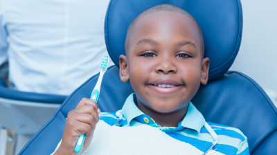 Smiling boy in a dental chair holding a toothbrush
